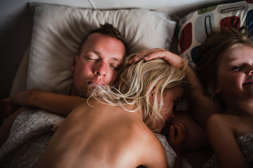 Father and kids sleeping in bed