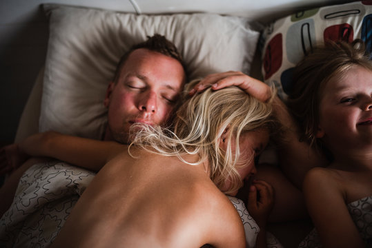 Father and kids sleeping in bed