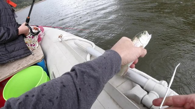 Catch and release rainbow trout at the lake on a rainy day.