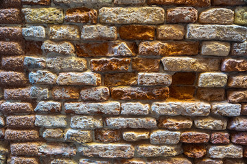 Old textured destroyed brickwork of a wall closeup.