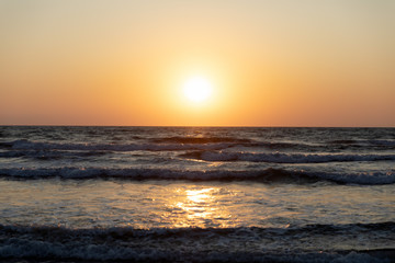Waves of the Mediterranean Sea with sea foam and spray. Beautiful sea on sunset background. Sundown. Seascape.