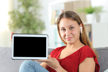 Fototapeta premium Satisfied woman with earbuds showing tablet screen