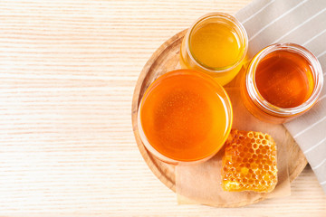 Tasty honey on white wooden table, top view. Space for text