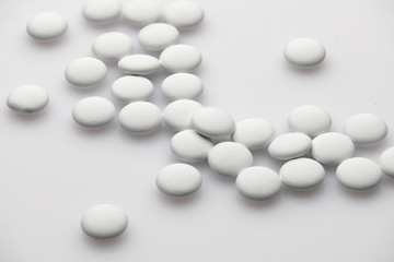 Group of white pills on white background - healthcare and medicament concept. Pharmaceutical industry. Pharmacy.