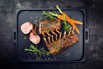 Gegrilltes Lamm Nacken Karree mit Karotten und Kräuter angeboten als Draufsicht auf einem Modern...