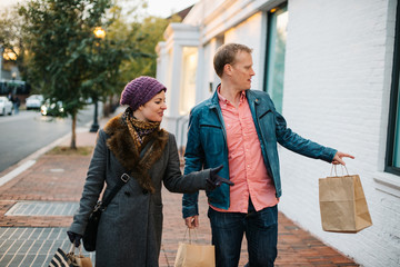 Caucasian couple wearing warm clothing window shopping from outdoors in the winter time.  - 312984887