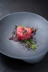 Gourmet fish tartar raw from tuna fillet with seaweed, umeboshi and Japanese spice as closeup on...