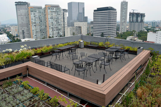 azotea verde con mesas y sillas en la ciudad
