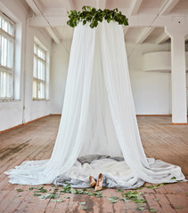 Fototapeta na wymiar Bride's white canopy suspended in a photo studio