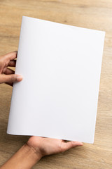 Obraz premium Ethnic model holding an A5 or half letter sized brochure 