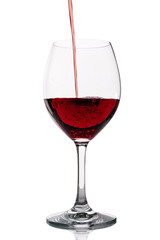 Red wine pouring into clean glass on white background with bubbles. Tasty wine being poured in wine glass. Studio shot