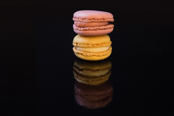French macaroons, varied selection of cookies with a black background.