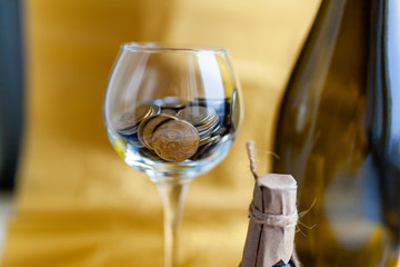 Half empty, half full transparent drinking glass with coins