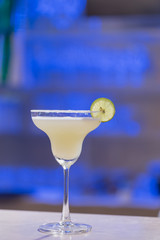 Glass of Margarita cocktail.Backdrop in a liquor bar.
