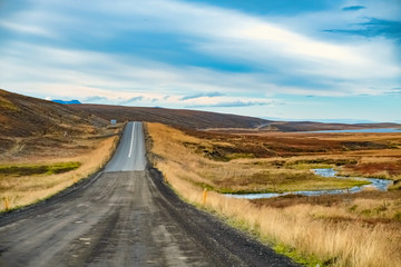 A dirt road against a hill with vanishing point, Husavik, Iceland