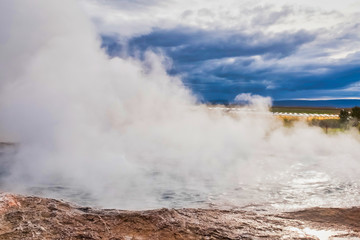 Fototapeta na wymiar Steam around the hole where the hot water is bubbling, geothermal energy, Husavik, Iceland