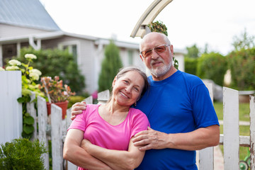  Mature couple at wicket gate of   village cottage