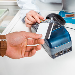 Cropped view of man paying with paypass in pharmacy