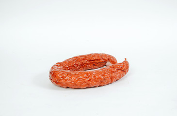 Sausage on a white background. Food and meal concept. Smoked red juniper sausage. Preparing a meal,...