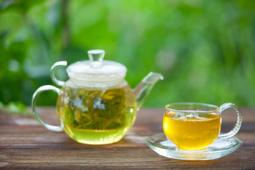 Crystal cup with green tea on table