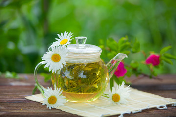Fototapeta na wymiar green tea with chamomile in cup