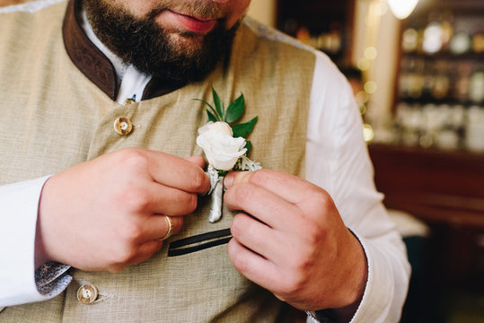 Bearded young groom adjusting his bottoniere