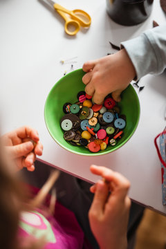Hand in bowl full of buttons