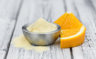 Wooden table with orange fruit powder (selective focus)