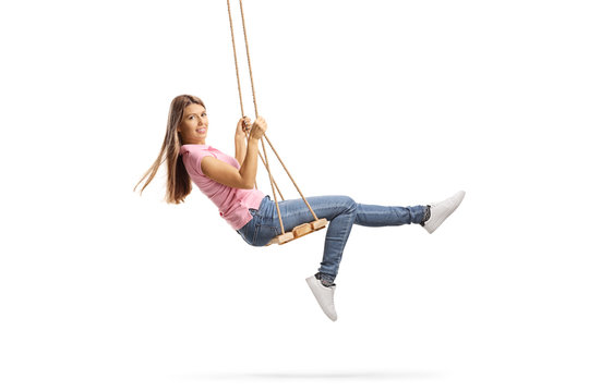 Young woman with long hair swinging on a wooden swing
