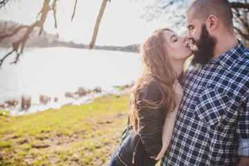 Fototapeta premium A girl and a guy are walking in the park. Portrait of a couple, a love story.Happy smiling, loving couple together outstretched at beautiful nature.
