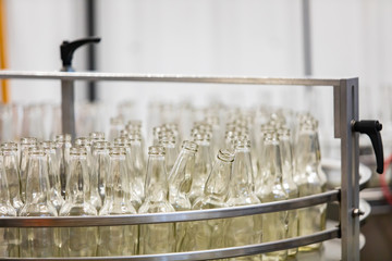 a lot of new white glass empty beer bottles on machine, selective focus close up view, conveyor...