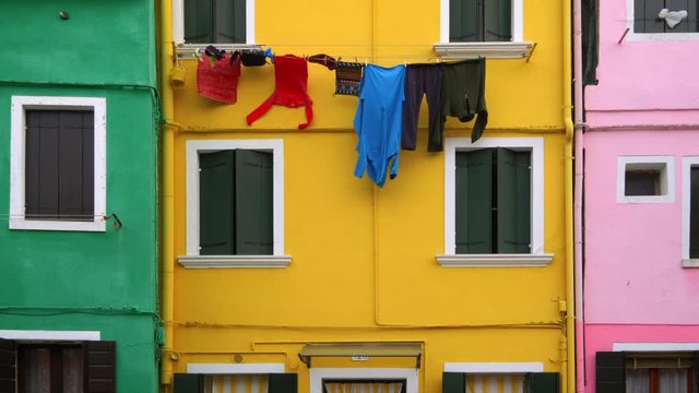 Laundry hanging to dry from clothesline in colorful neighborhood on Burano Island, Venice, Italy
