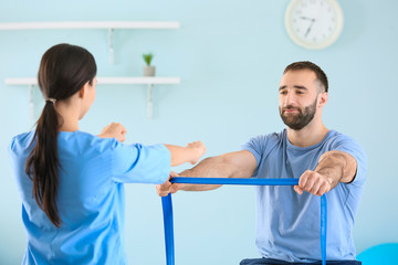 Obraz premium Physiotherapist working with male patient in rehabilitation center