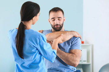 Obraz premium Physiotherapist working with male patient in rehabilitation center