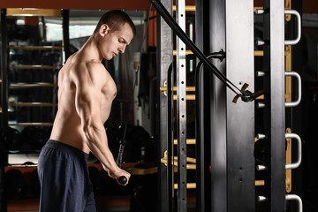 Sporty muscular man training in gym