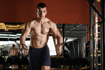 Fototapeta na wymiar Sporty muscular man training in gym