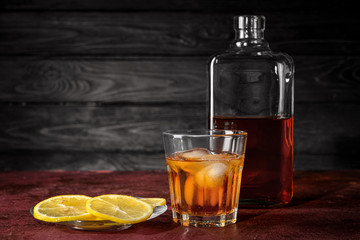 Bottle and glass of whiskey on table. Concept of alcoholism