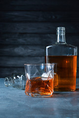 Bottle and glass of whiskey on table. Concept of alcoholism