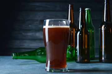 Glass and bottles of beer on table. Concept of alcoholism