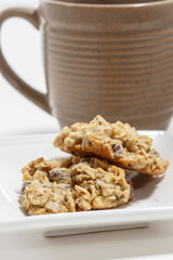 Oatmeal raisin cookies on white plate with mug