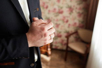 Hands of groom getting ready in suit