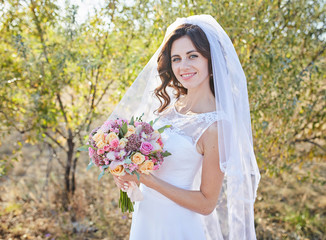 Fototapeta na wymiar beautiful fabulous happy brunette bride with stylish bouquet