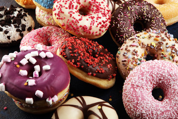 assorted donuts with chocolate frosted, pink glazed and sprinkles donuts
