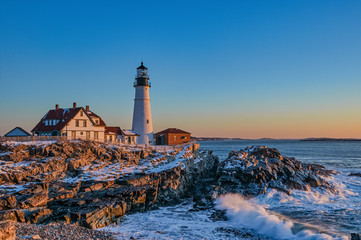 Maine's famous Portland Head Lighthouse at sunrise on a snow covered winter morning