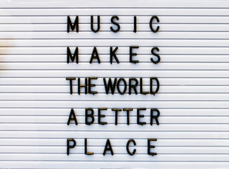 Music makes the world a better place concept made by plastic letters on a white board. 