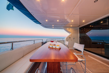 Beautiful shot from the yacht of wine glasses and snacks on the wooden table
