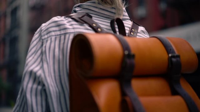 Slow motion effect of Caucasian hipster tourist with trendy backpack listening audio guide during exploring new city area on weekend, concept of youth lifestyle and recreation