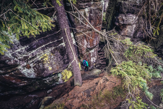Tourist in rock labirynth in Mount Ostas reserve in Table Mountains, part of Broumovsko protected area in Czech Republic