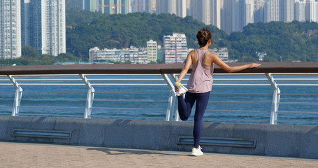 Woman stretch legs before running at outdoor