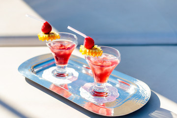 High angle shot of red cocktails with strawberries on the tray